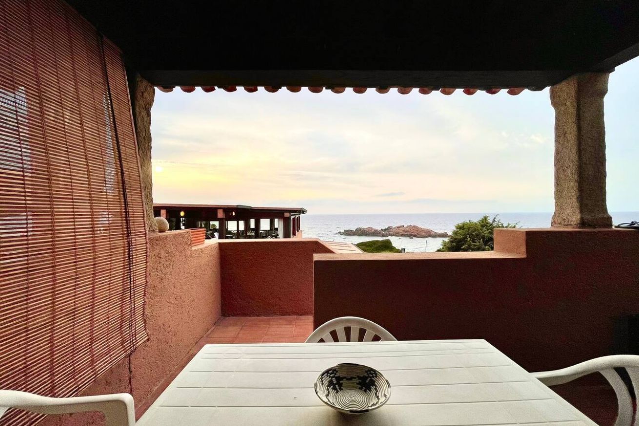 Eine Terrasse mit Tisch und Stühlen mit Blick auf die Küste.