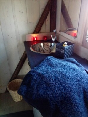 Ein Badezimmer mit Waschbecken, Spiegel und Kerzen.