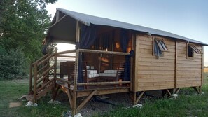 Una baita di legno con un balcone, un portico coperto e una finestra.