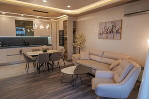 Uma sala de estar moderna com sofá, mesa de centro e área de jantar com cadeiras.