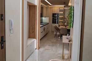 A modern kitchen with a built-in oven, a dining area with a table and chairs, and a bench. - Designer Luxery 2 BR Apartment with Hot Mineral Water & Mineral Pool (VARNA)