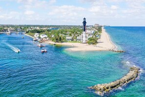 A coastal area with a lighthouse, calm waters, and a sandy beach. - Walk to Beach & Restaurants | Hot Tub | Beach Gear (Pompano Beach)