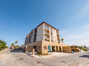 A multi-story hotel with a modern design, featuring a prominent entrance and a landscaped area with cacti. - Ameth: Stylish 3BR in Downtown with Rooftop Pool (Cabo San Lucas)