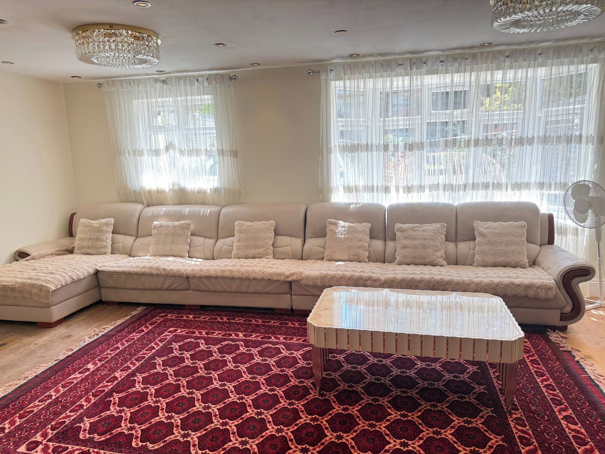 A living room with a sectional sofa, a coffee table, and a patterned rug.