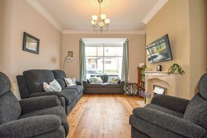A living room with a sofa set, a fireplace, a television, and a bookshelf. - Sea Escape - Convenient location (North Yorkshire)