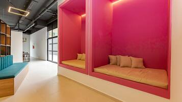 A modern interior with a seating area featuring cushioned benches and a teal sofa.