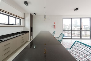 Una cocina moderna con una encimera larga, armarios y un amplio ventanal con vistas a la ciudad.