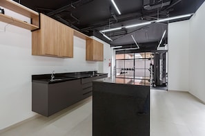 Una cocina moderna con encimera negra, armarios de madera y una isla grande.