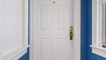 Un couloir avec une porte blanche, des murs bleus et un plancher en bois.