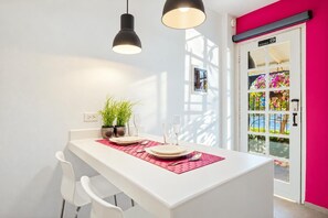 A dining area with a white table, two potted plants, and a red placemat. - 1BR/1BA 5 MINS to Beach | Lagoon Studio by Bocobay (Noord)