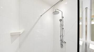 Refresh in a sleek, modern walk-in shower featuring a rainfall showerhead, handheld shower, and elegant white tiles.