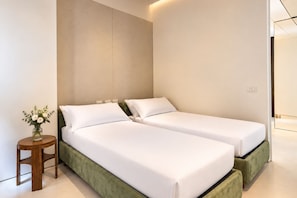 A modern hotel room with two single beds, a small wooden side table, and a vase of flowers. - Apartments Florence - Signoria Farine Panoramic view (Firenze)