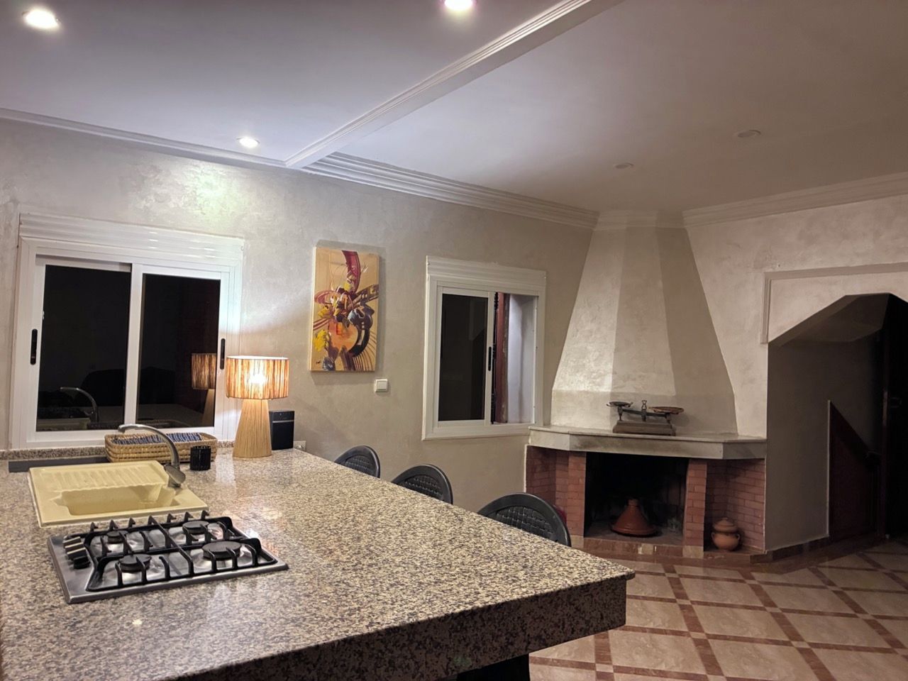 Una cocina con encimera de granito, estufa a gas y chimenea.