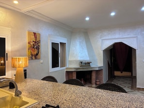 A kitchen with granite countertops, a built-in stove, and a dining area with chairs. - Vrbo Property (Lagfifat)