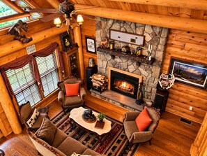 A cozy cabin interior with a fireplace, wooden walls, and a stone accent wall. - Harriman Reservoir Log Cabin- 10 Min to Mount Snow (Wilmington)