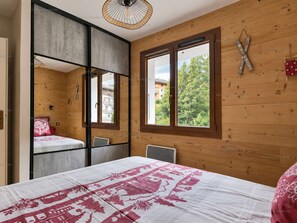 Une chambre à coucher avec un lit, une fenêtre et une vue sur l’extérieur.