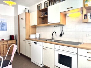 Una cucina moderna con lavastoviglie, forno e macchina da caffè sul piano di lavoro.