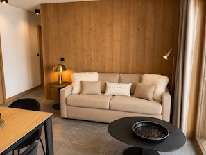 Ein modernes Wohnzimmer mit einer Couch, einem runden Couchtisch und einer Lampe.