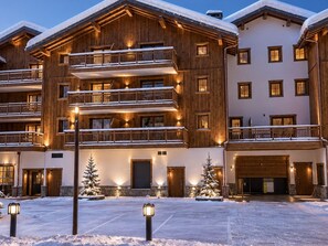 Ein mehrstöckiges Hotel mit hölzernen Balkonen und verschneiter Umgebung.