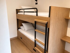 Ein Etagenbett mit Holzrahmen und einem Bettkasten darunter.