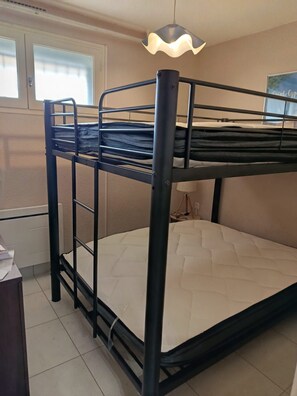 A bunk bed with a mattress and a headboard. - St Cyprien Terrace apartment 2 minutes from the port and the beach (Saint-Cyprien)