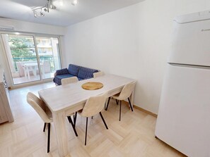 Cozinha moderna com mesa de jantar, cadeiras e frigorífico.