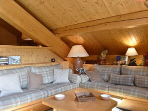 A cozy living room with a wooden ceiling, two plaid sofas, a coffee table, and decorative items. - Apartment at the slopes - 8 guests (Méribel)