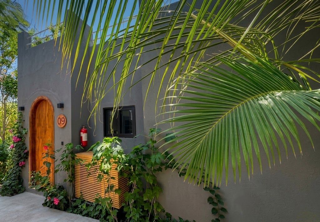 Un edificio con una puerta de madera identificada con el número 09, un extintor y una ventana.