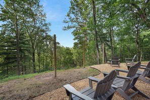 A forested outdoor area with wooden benches and a fire pit. - Tiny Pines - Ellijay, GA (Ellijay)
