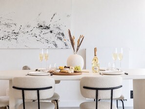 A dining table set with plates, glasses, a bottle of Ruinart champagne, and a centerpiece with dried plants. - Villa Awans - Luxury Stay for 6 With Pool (Awans)