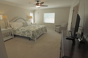 A bedroom with a bed, a chair, a desk, a ceiling fan, and a TV. - Sunshine Retreat: SW facing pool, 2 En-Suites #36 (Rotonda West)