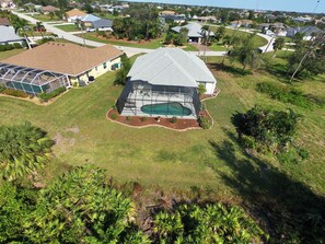 A residential area with a house featuring a large covered patio and a swimming pool. - Sunshine Retreat: SW facing pool, 2 En-Suites #36 (Rotonda West)