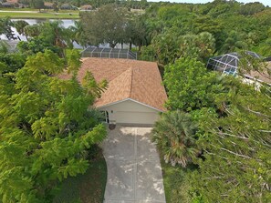 A residential property with a tiled roof, a garage, and a paved driveway. - Serene West Facing Pool -Rotonda West #15 (Rotonda West)