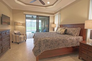 Ein Schlafzimmer mit einem großen Bett, einem Sessel, einer Kommode und einer Lampe.