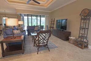 A spacious living room with a sofa, a coffee table, a TV, and a fireplace. - Rotonda River Villa pool home #1125 (Rotonda West)
