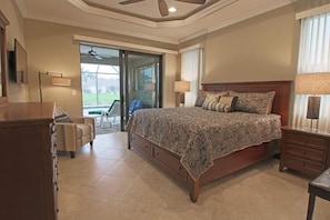 A bedroom with a large bed, a desk, and a chair. - Rotonda River Villa pool home #1125 (Rotonda West)