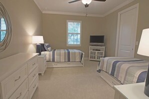 A bedroom with two beds, a dresser, a TV, and a ceiling fan. - Rotonda River Villa pool home #1125 (Rotonda West)