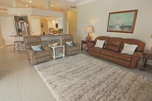 A living room with a brown leather sofa, two armchairs, a coffee table, and a rug. - Spacious Pool and Expansive Canal Views #811 (Rotonda West)