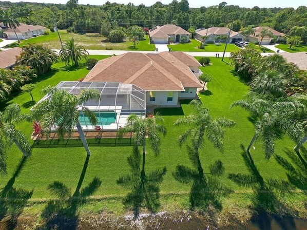 Un quartier résidentiel avec des maisons, une piscine et des palmiers.