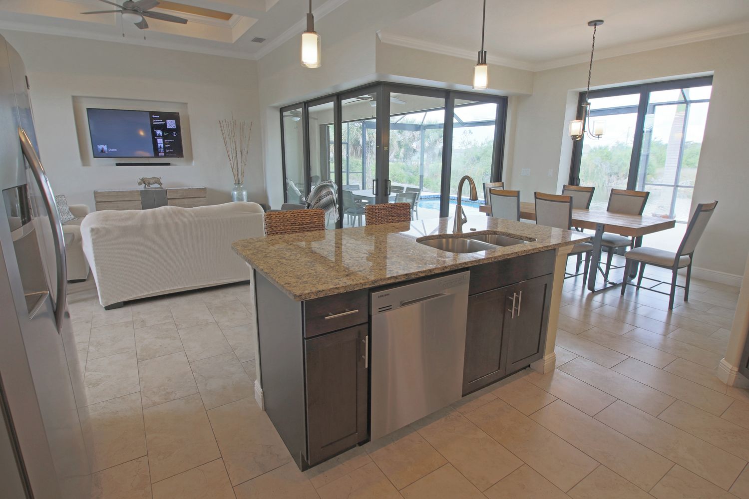 A modern kitchen with granite countertops, stainless steel appliances, and a dining area with a large window.