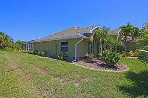 A single-story house with a sloped roof, a covered porch, and a well-maintained lawn. - Lakeside Luxury #198 (Rotonda West)