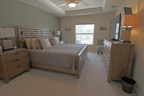 A bedroom with a bed, nightstands, a dresser, a chair, a television, and a window. - Lakeside Luxury #198 (Rotonda West)