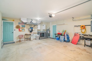 Eine Garage mit Werkbank, Stauraumschränken und einem roten Surfbrett.