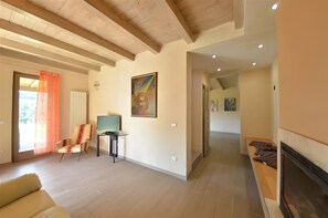 A spacious living area with a fireplace, a television, and a painting on the wall. - Villa 'In Collina Con Piscina' with private pool, private garden and Wi-Fi (Lucca)