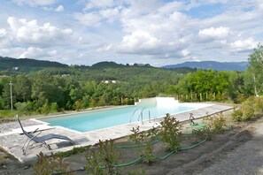 Ein Schwimmbecken mit Blick auf eine gebirgige Landschaft.