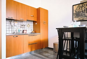 A kitchen with wooden cabinets, a tiled backsplash, and a small trash bin. - Panciatichi 10 - Careggi - University - Downtown (Firenze)
