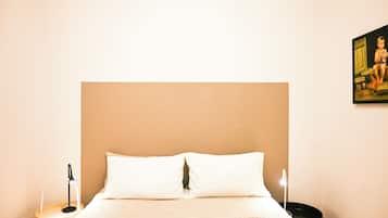Ein Hotelzimmer mit einem großen Bett, einem Nachttisch, einer Lampe und einem Bild an der Wand.