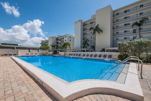 A rectangular swimming pool with a clear blue water surface, surrounded by a brick walkway. - Siesta Key Beach Escape- 2 BR / 2BA Condo by RVA (Sarasota)