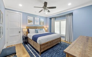 A bedroom with a bed, bedside tables, a ceiling fan, and a window with curtains. - Chillville: Pool, Playground & Bikes (Santa Rosa Beach)
