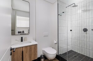 Moderni kylpyhuone, jossa on suihku, wc ja pesuallas.